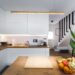 A kitchen with a wooden counter top next to a plant