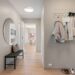 A contemporary hallway with minimalist decor featuring coats, shoes, and a stylish mirror.