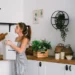 A woman sorting organic waste in a stylish kitchen promoting eco-friendly living.