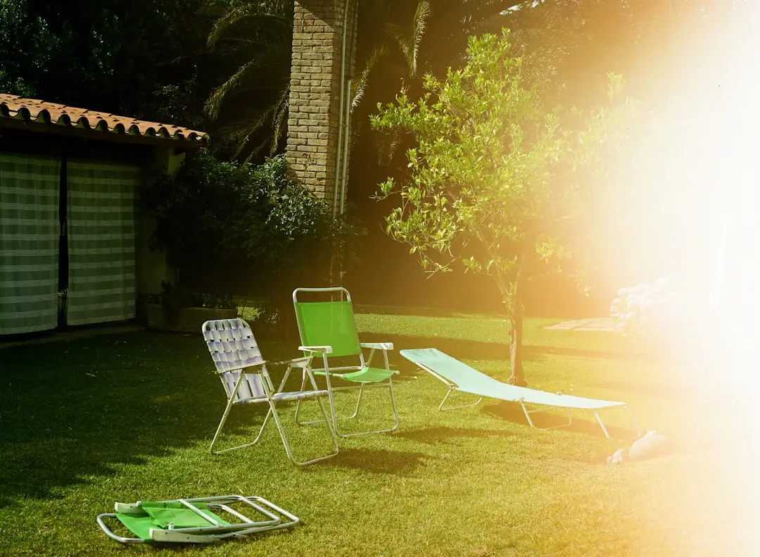 Lawn chairs and lounge on green grass near house